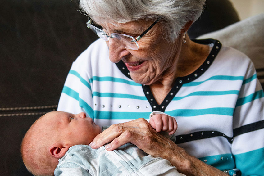 ältere Frau mit Baby im Arm
